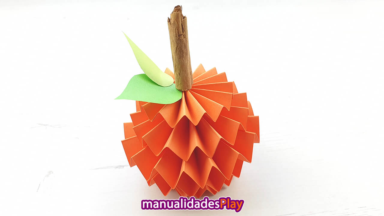 Manualidad de calabaza realizada con hojas de papel de color naranja