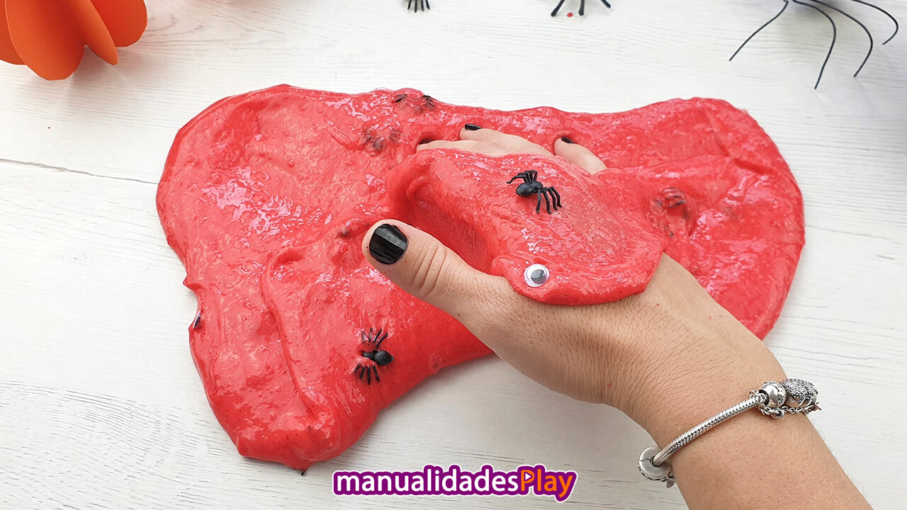 Slime de halloween de color rojo con arañas y ojos de plástico
