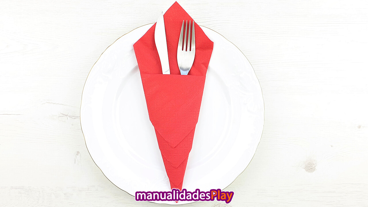 Servilleta de papel roja doblada en forma de cono doblada como portacubiertos