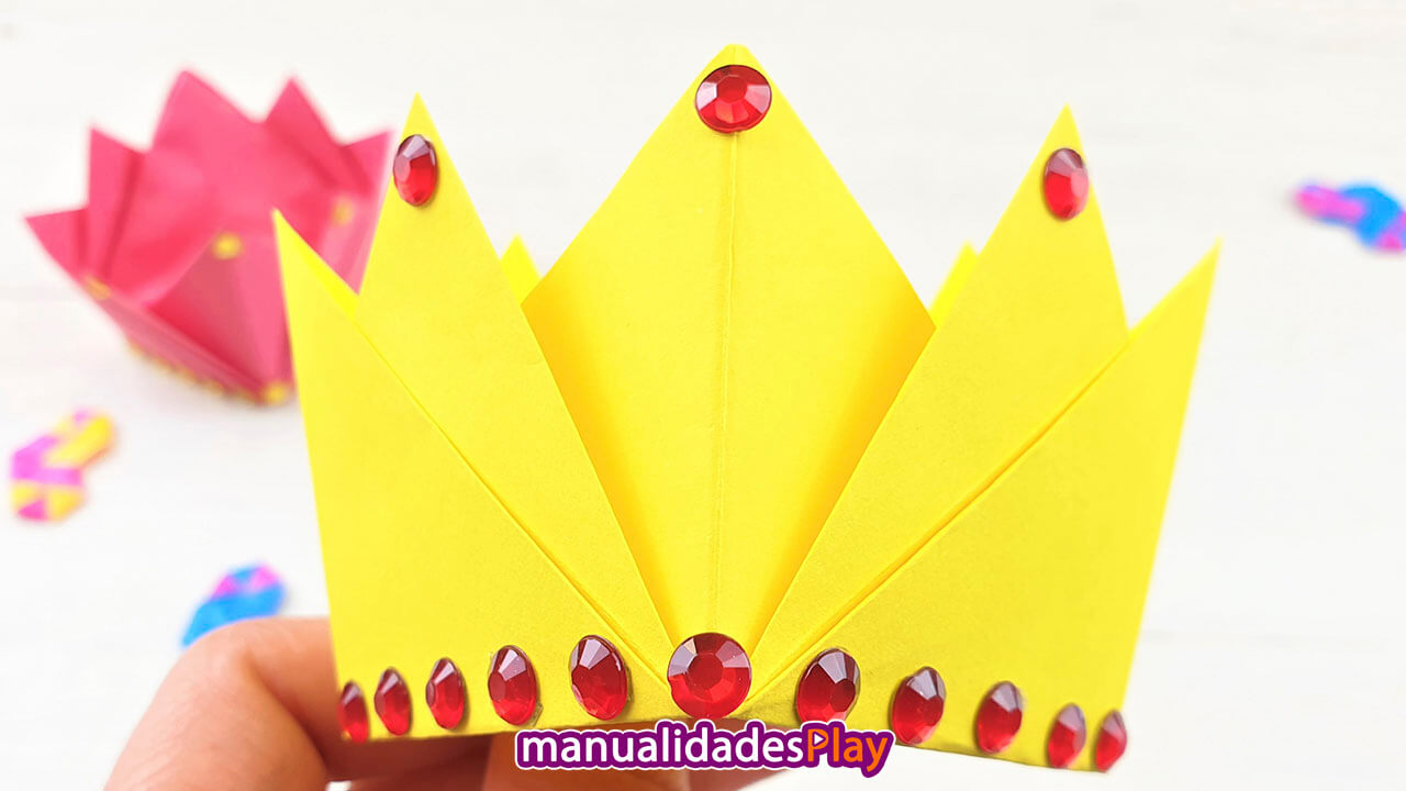 Corona de origami hecha con papel amarillo y perlas
