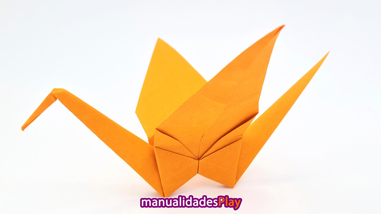 grulla de origami realizada con hoja de papel de color naranja