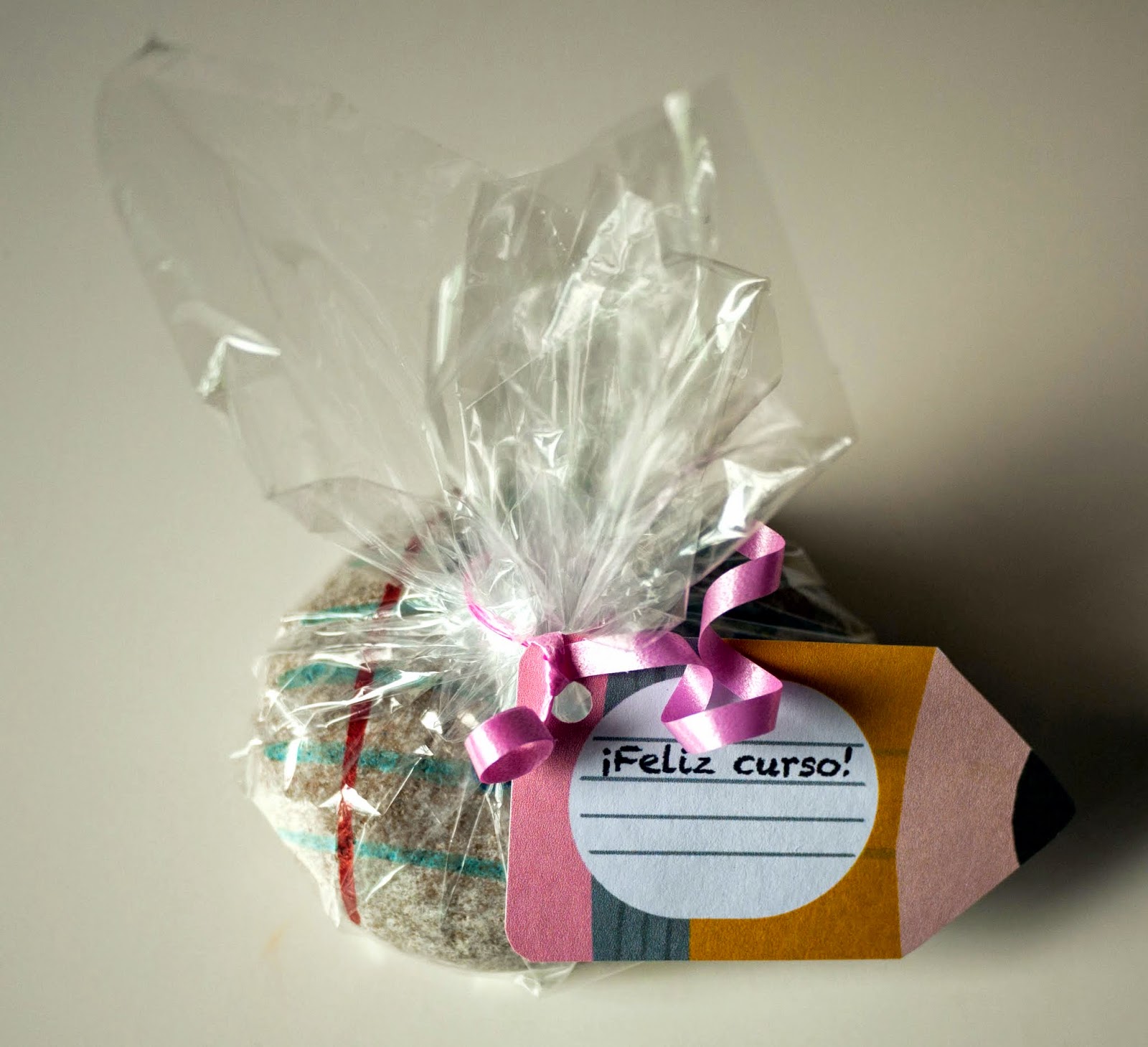 Pisapapeles de piedra para profesores envuelto para regalo con papel de celofán y con una etiqueta de lápiz