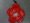 Colgante con forma de flor de color rojo realizado con una botella roja de plástico