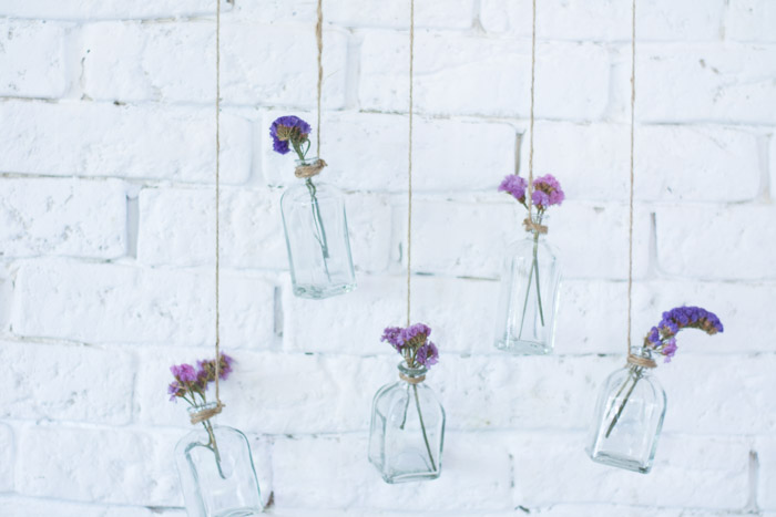 Rama con botellas de cristal y flores